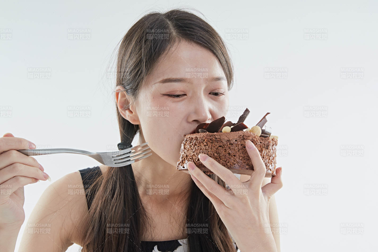 喝红酒品尝蛋糕的年轻女性图片