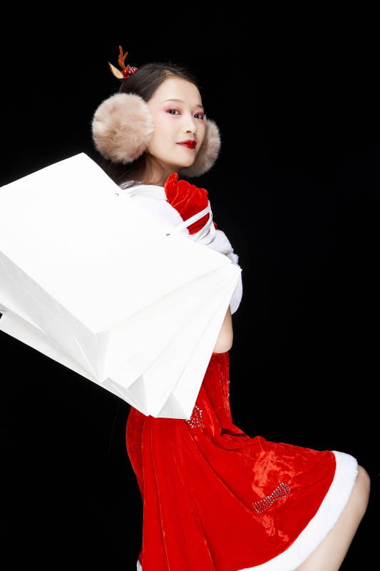 身穿圣诞服饰手提购物袋性感可爱的圣诞女郎图片