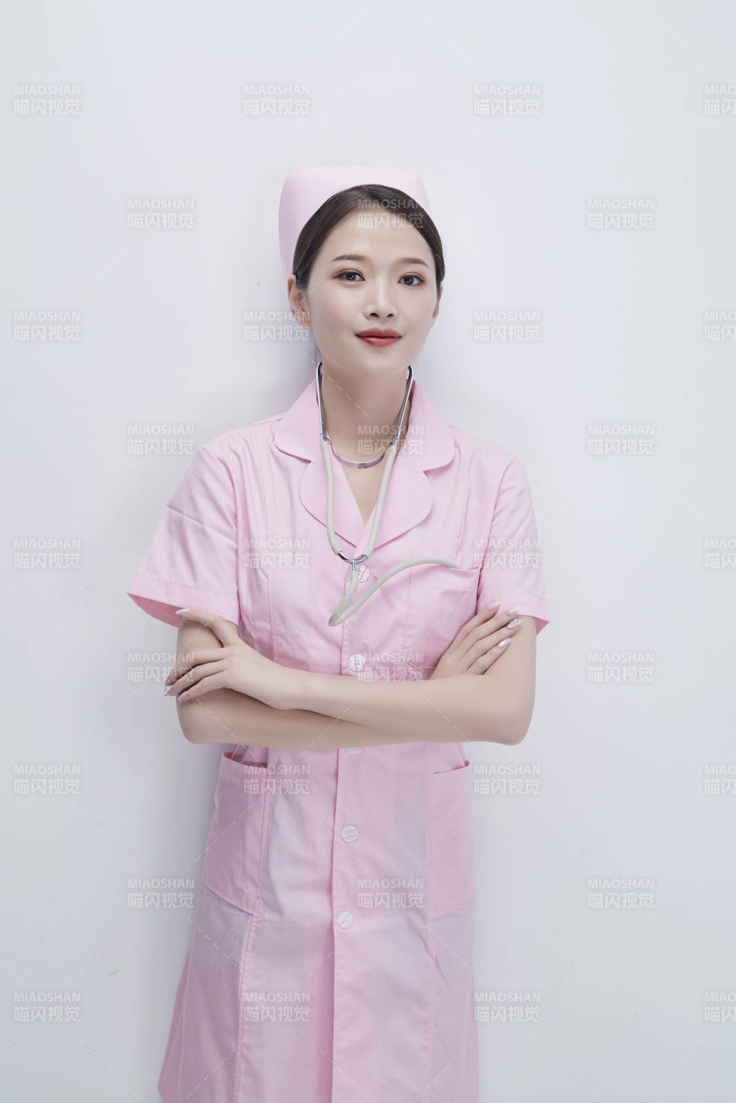 身穿粉色护士服佩戴听诊器的女性医护人员图片