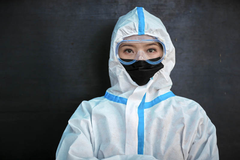 穿白色防护服佩戴护目镜口罩的女性防护人员图片