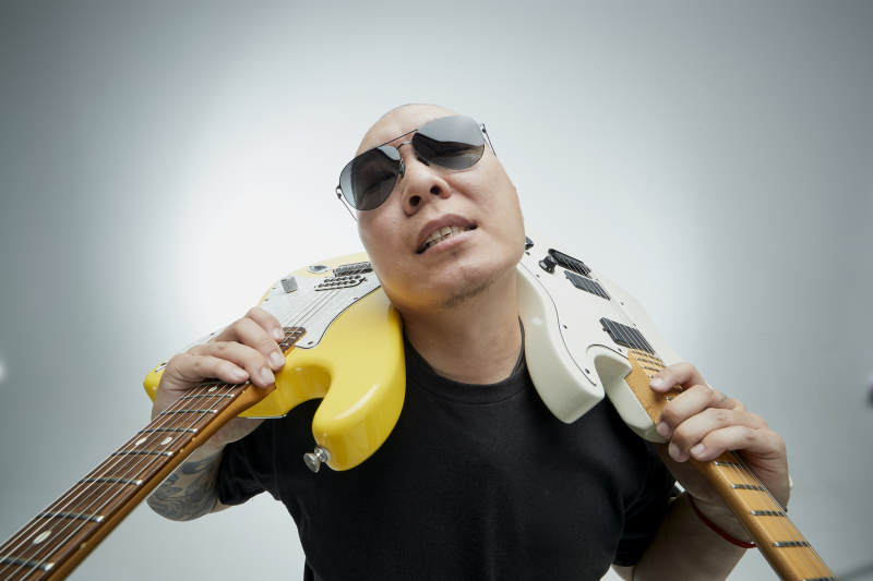 手持电吉他展示演奏的亚洲男性摇滚乐手人像图片