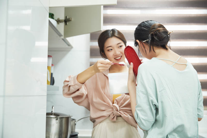 在厨房烹饪美食的亚洲闺蜜少女图片