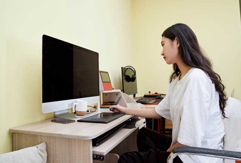 居家在电脑前创作插画的年轻美女图片