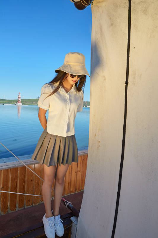 在湖畔木制帆船上的亚洲美女图片