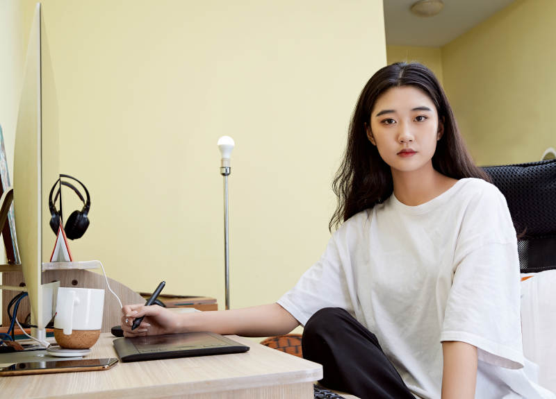 居家在电脑前创作插画的年轻美女图片