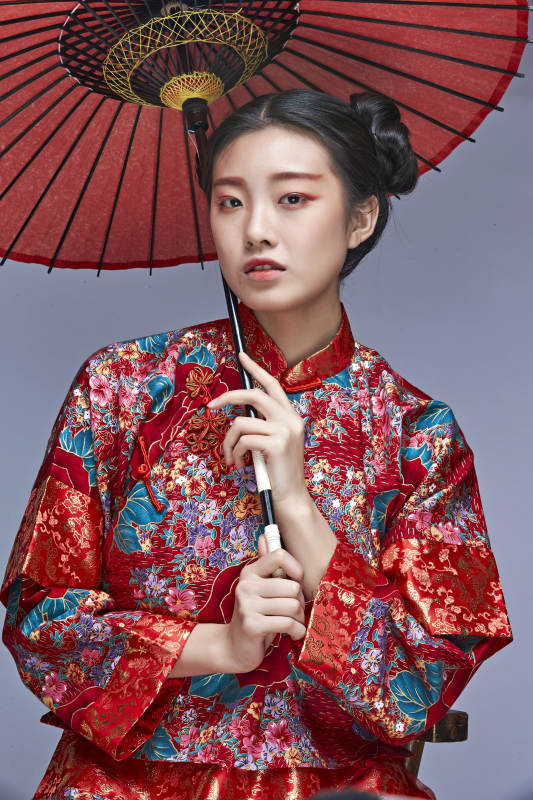 身穿中国秀禾服手撑油纸伞的亚洲女性模特图片