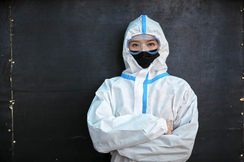 穿白色防护服佩戴护目镜口罩的女性防护人员图片