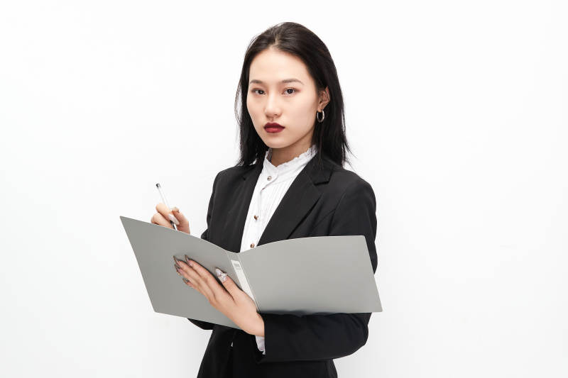 身穿西服拿着文件夹的美丽商务女士图片