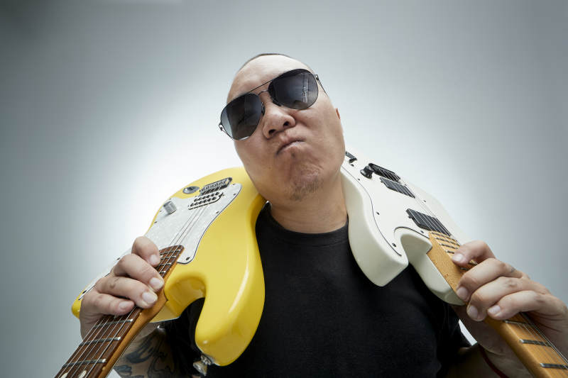 手持电吉他展示演奏的亚洲男性摇滚乐手人像图片