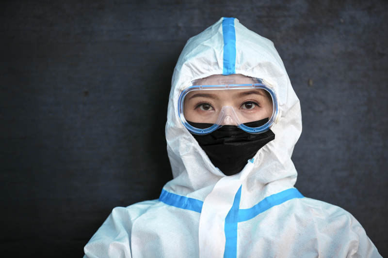 穿白色防护服佩戴护目镜口罩的女性防护人员图片