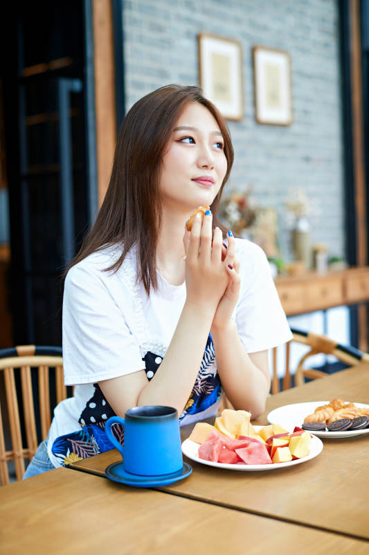 坐在咖啡图书馆吃东西的可爱少女图片