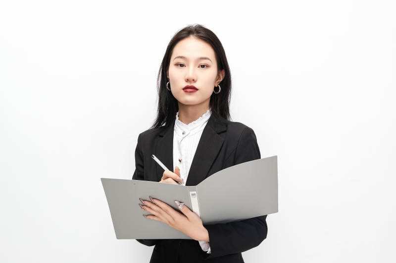身穿西服拿着文件夹的美丽商务女士图片