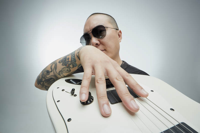 手持电吉他展示演奏的亚洲男性摇滚乐手人像图片