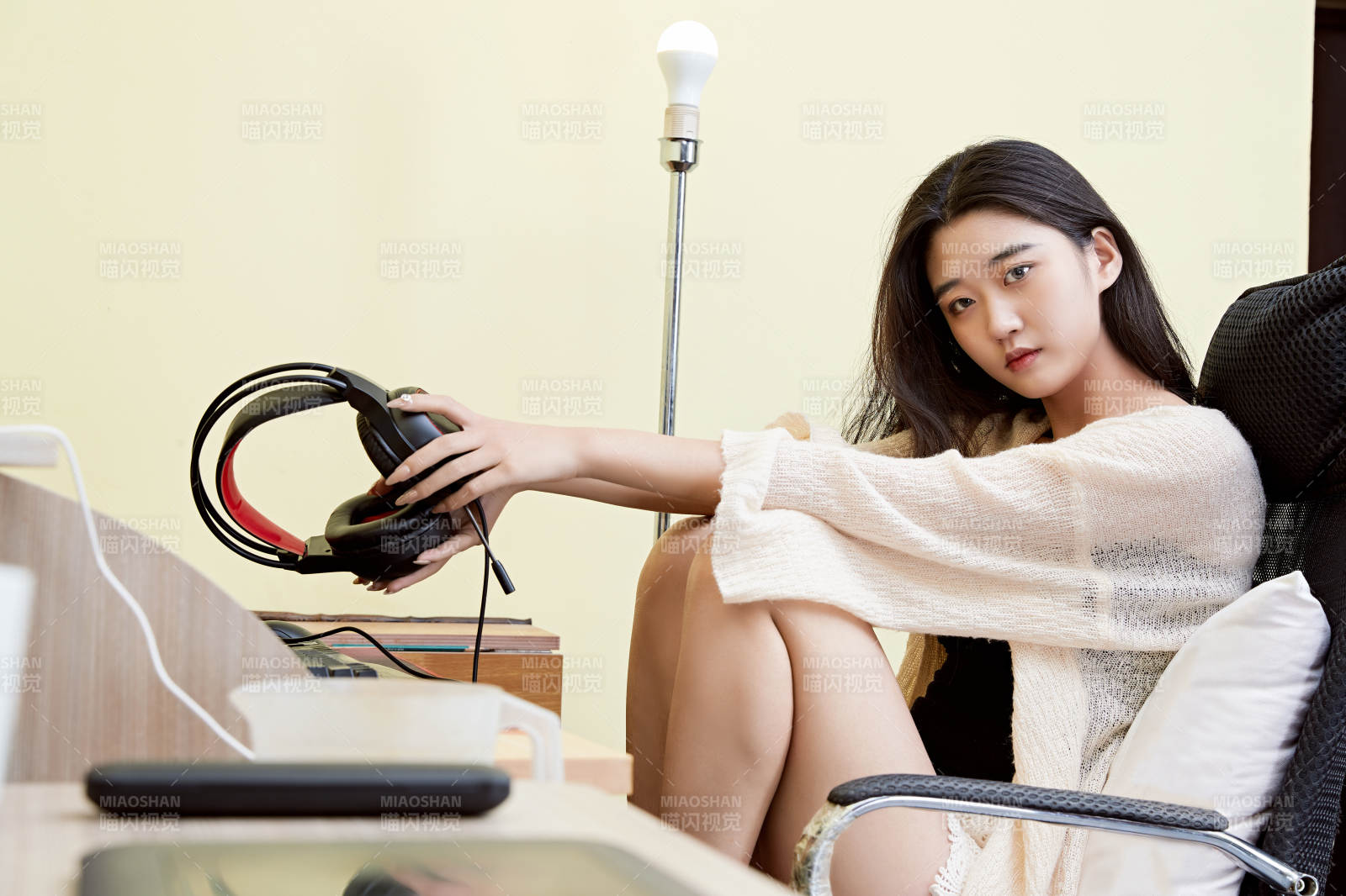 在家里坐在椅子上打游戏的美丽女孩图片