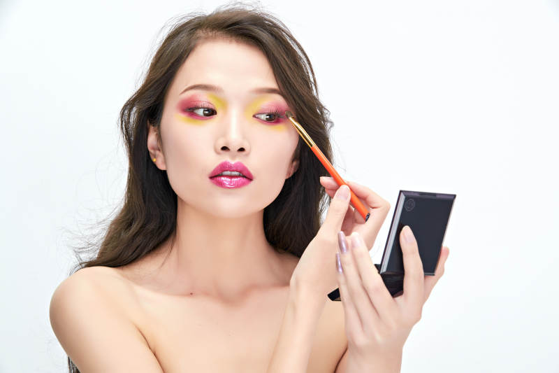 白色背景下棚拍化妆中的美女图片