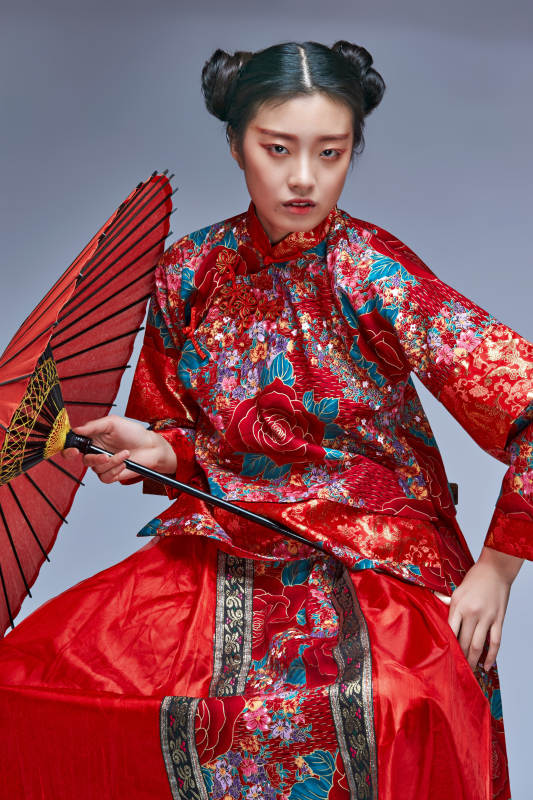 身穿中国秀禾服手撑油纸伞的亚洲女性模特图片