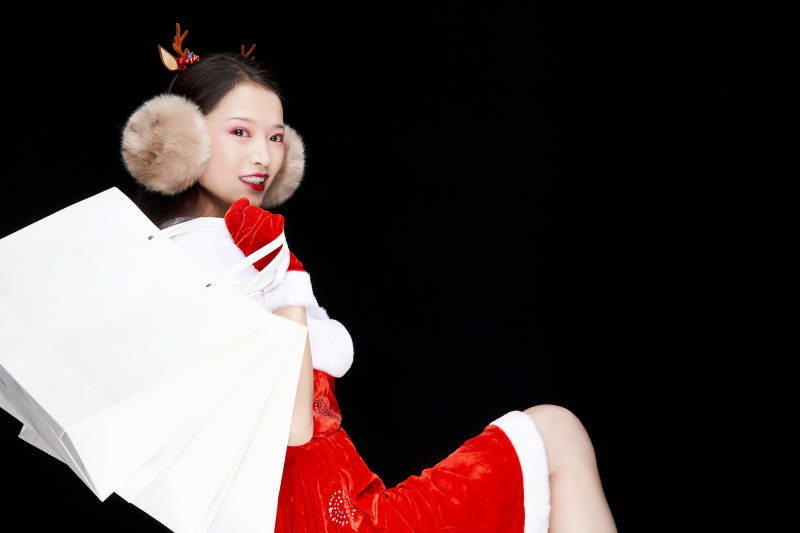 身穿圣诞服饰手提购物袋性感可爱的圣诞女郎图片