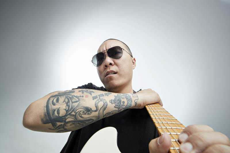 手持电吉他展示演奏的亚洲男性摇滚乐手人像图片