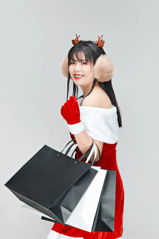 身穿圣诞服饰手提购物袋性感可爱的圣诞女郎图片