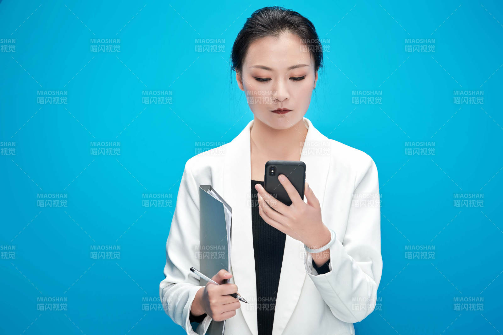 身穿西服拿着手机与文件夹的亚洲商务女士图片