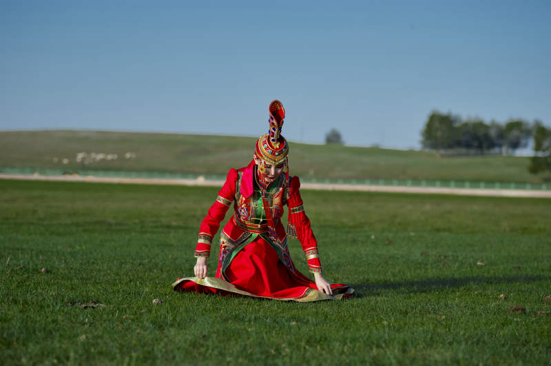 草原上穿着蒙古族传统服饰的亚洲年轻美少女图片