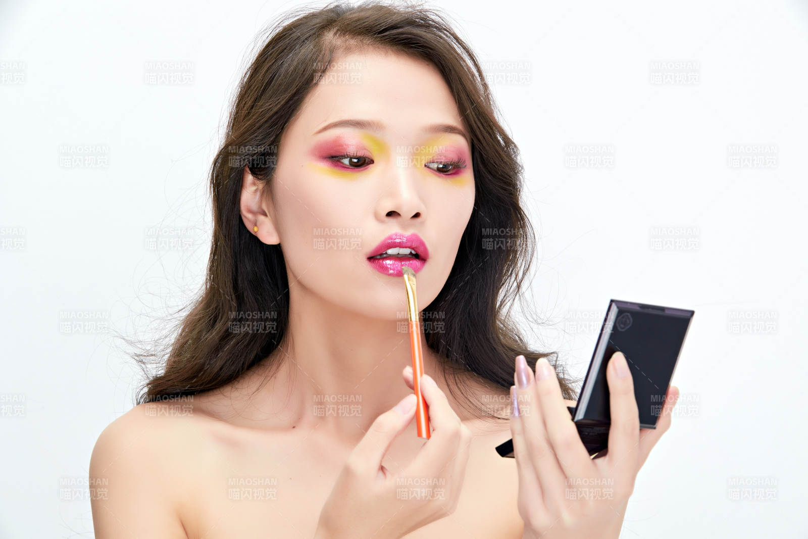 白色背景下棚拍化妆中的美女图片