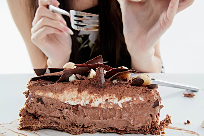 喝红酒品尝蛋糕的年轻女性图片