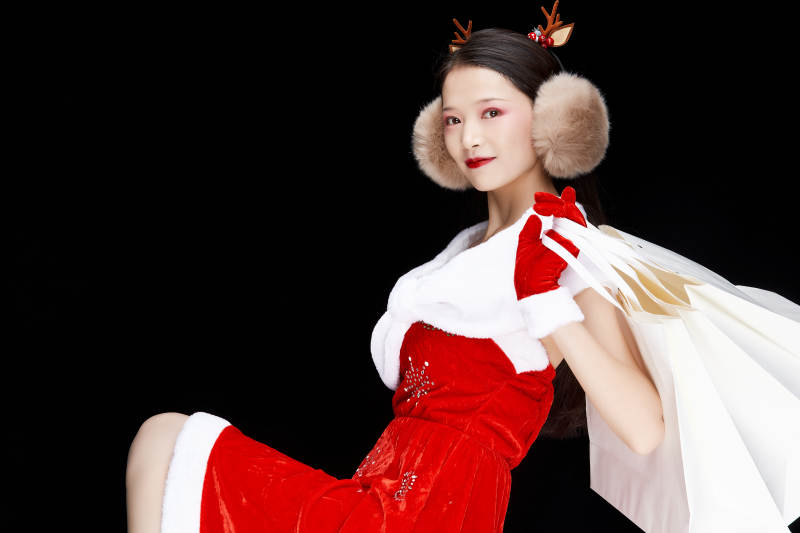 身穿圣诞服饰手提购物袋性感可爱的圣诞女郎图片