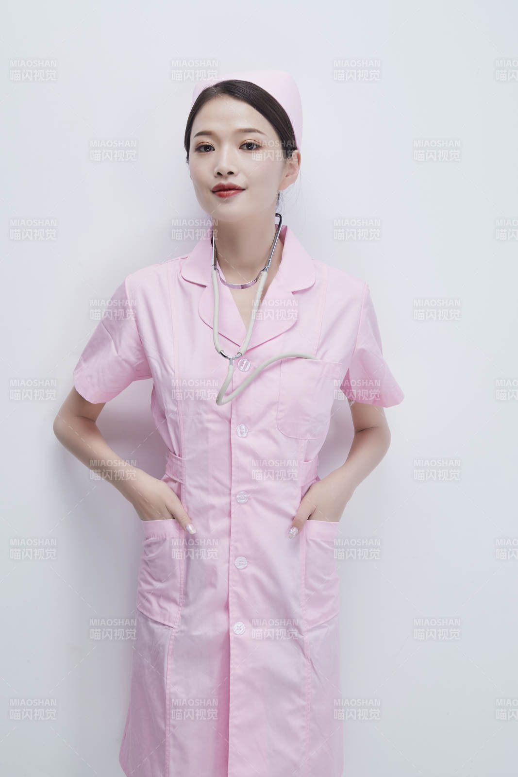 身穿粉色护士服佩戴听诊器的女性医护人员图片