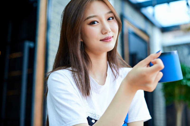 坐在咖啡图书馆吃东西的可爱少女图片