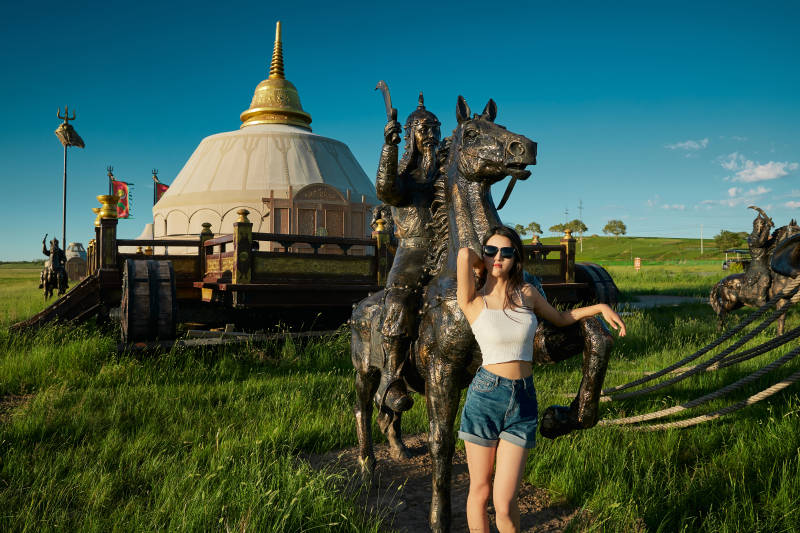 草原湿地公园游玩拍照的亚洲少女图片