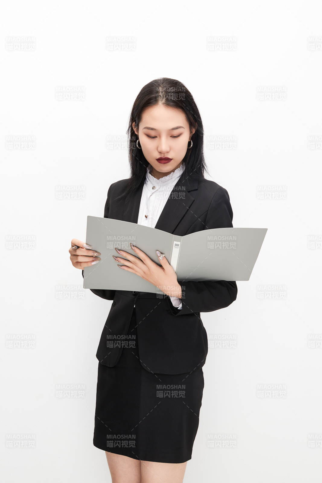 身穿西服拿着文件夹的美丽商务女士图片