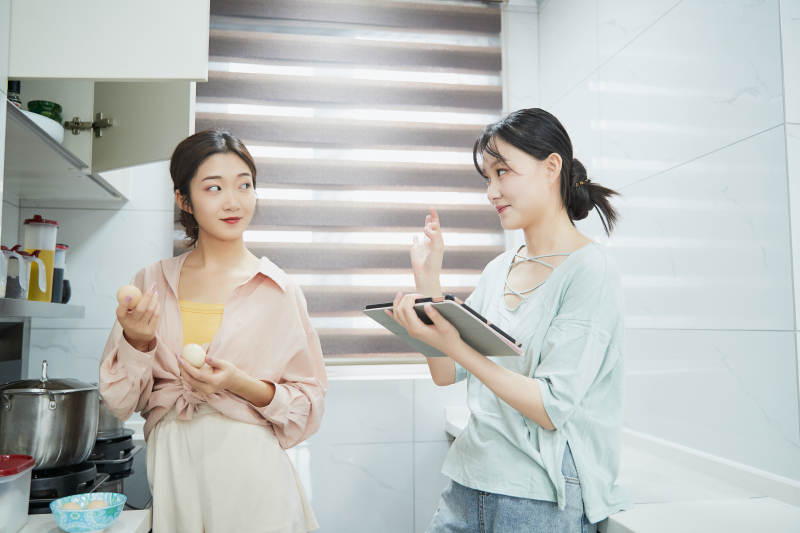 在厨房烹饪美食的亚洲闺蜜少女图片