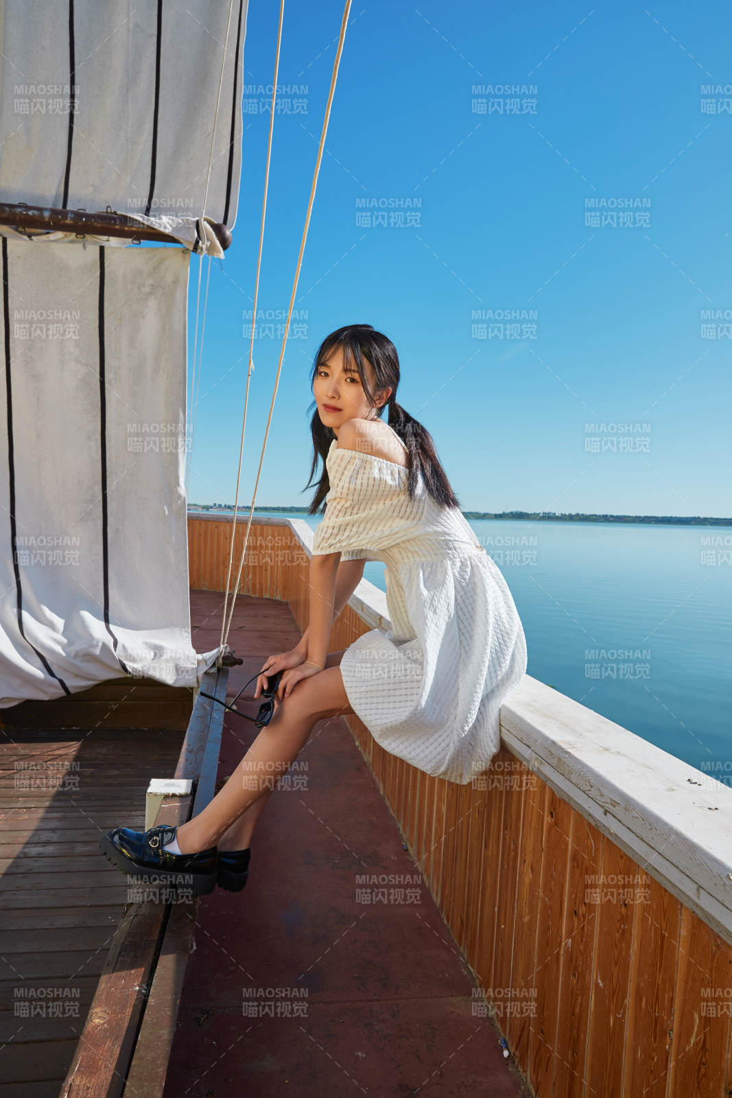 在湖畔木制帆船上的亚洲美女图片