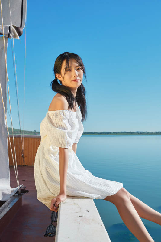 在湖畔木制帆船上的亚洲美女图片