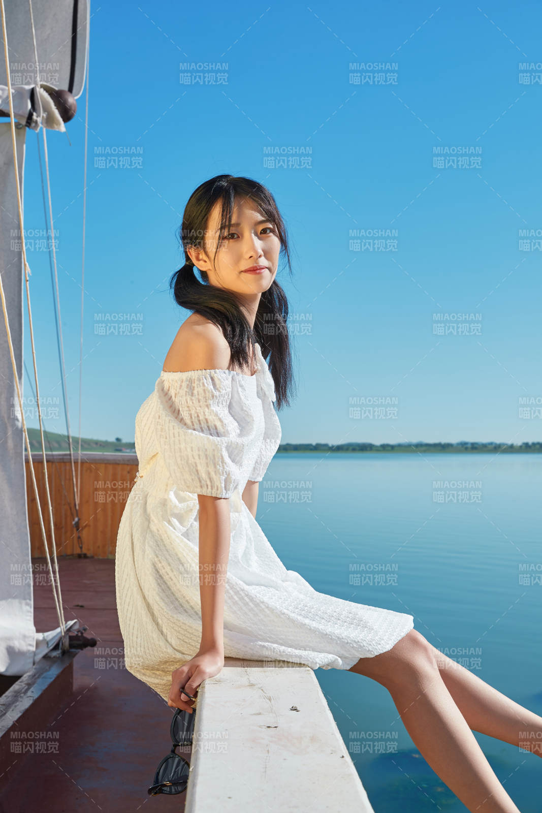 在湖畔木制帆船上的亚洲美女图片
