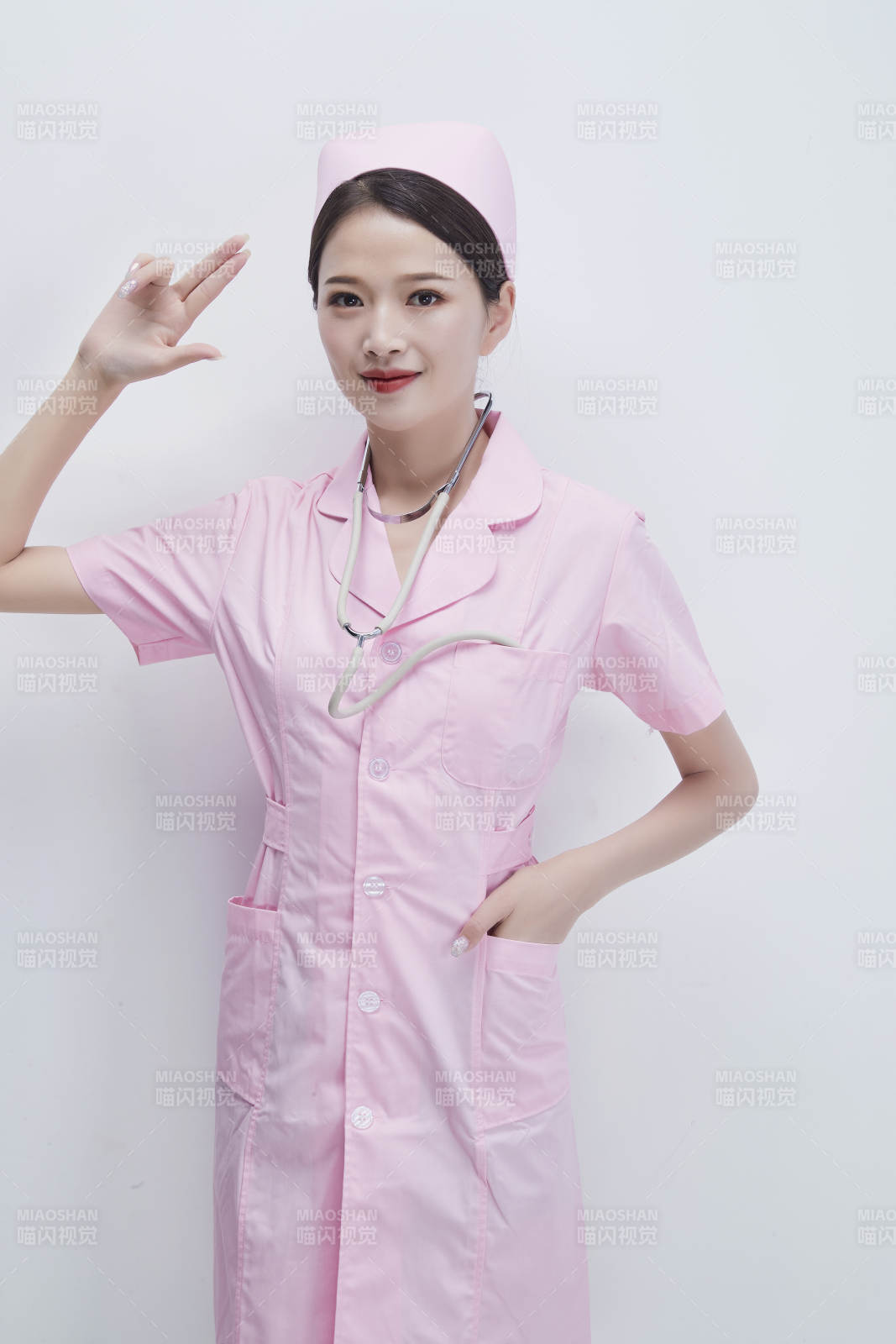 身穿粉色护士服佩戴听诊器的女性医护人员图片