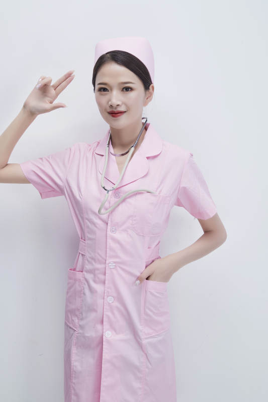 身穿粉色护士服佩戴听诊器的女性医护人员图片
