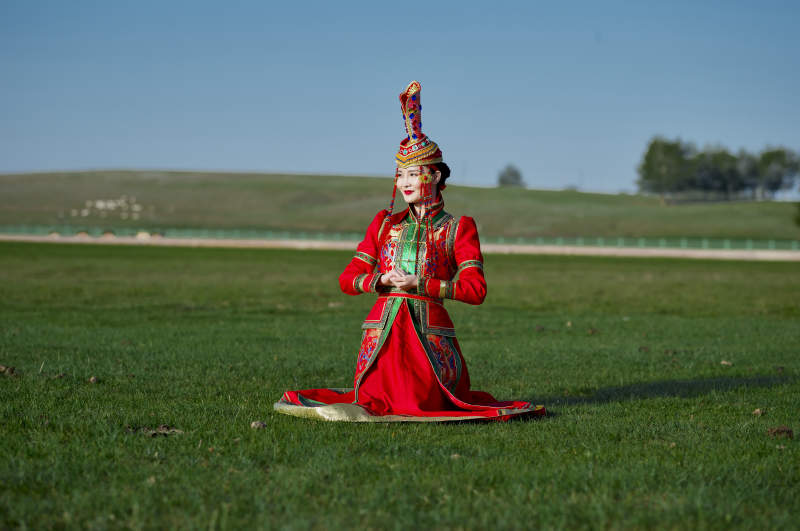 草原上穿着蒙古族传统服饰的亚洲年轻美少女图片