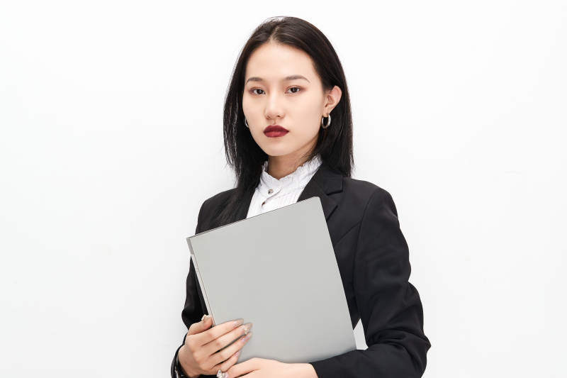 身穿西服拿着文件夹的美丽商务女士图片