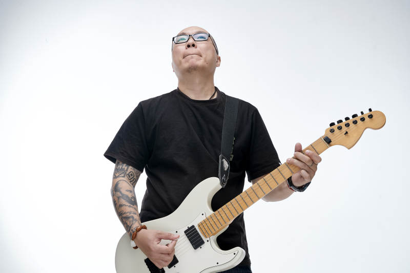 手持电吉他展示演奏的亚洲男性摇滚乐手人像图片