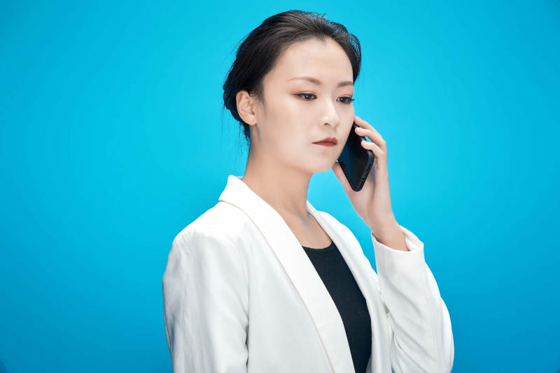 身穿西服拿着手机与文件夹的亚洲商务女士图片