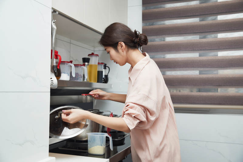 在厨房下厨的年轻亚洲女性图片