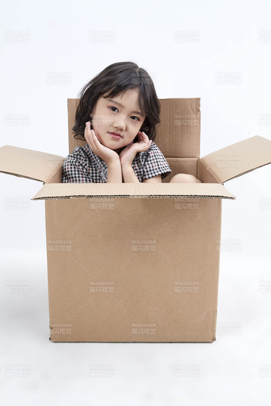 躲在纸箱中玩耍的调皮可爱亚洲小女孩儿童图片
