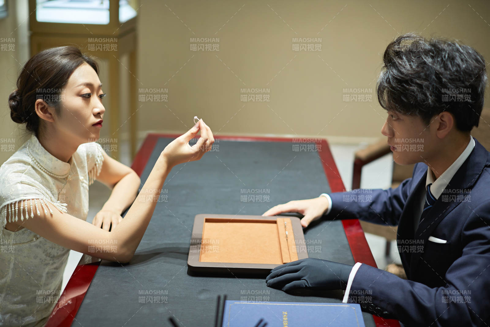 在珠宝店挑选石戒指的年轻情侣图片