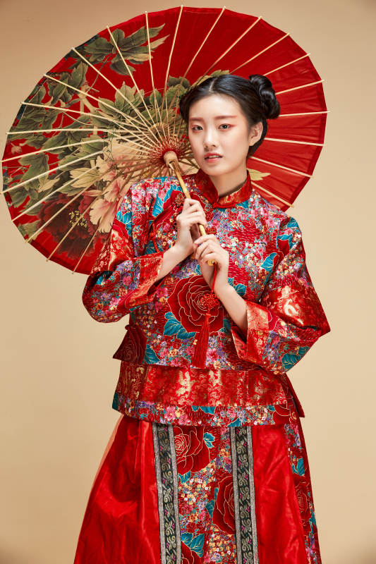 身穿中国秀禾服手撑油纸伞的亚洲女性模特图片