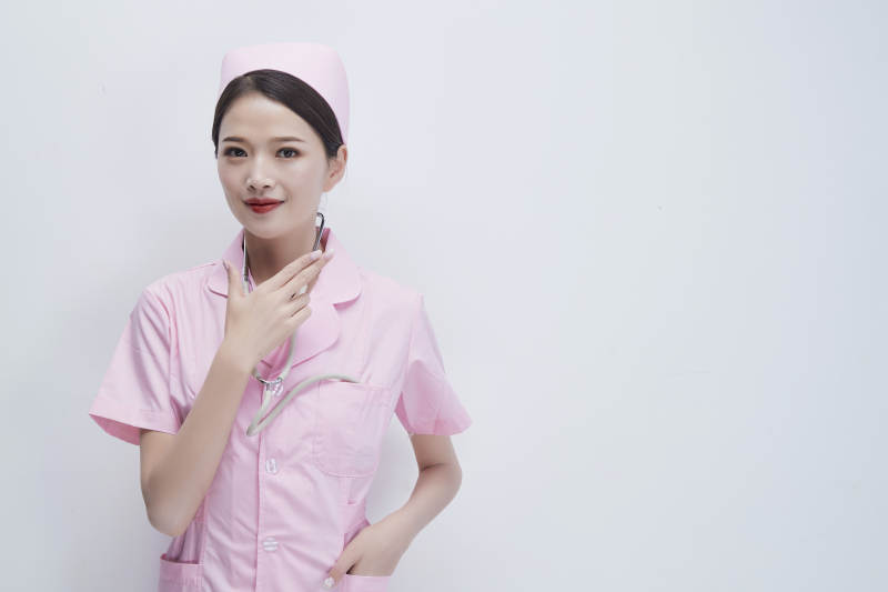 身穿粉色护士服佩戴听诊器的女性医护人员图片