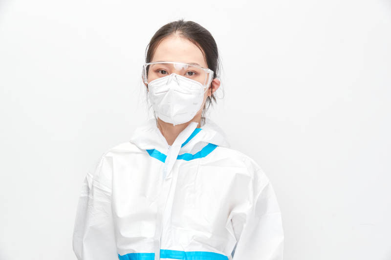穿白色防护服佩戴护目镜口罩的女性医疗人员图片