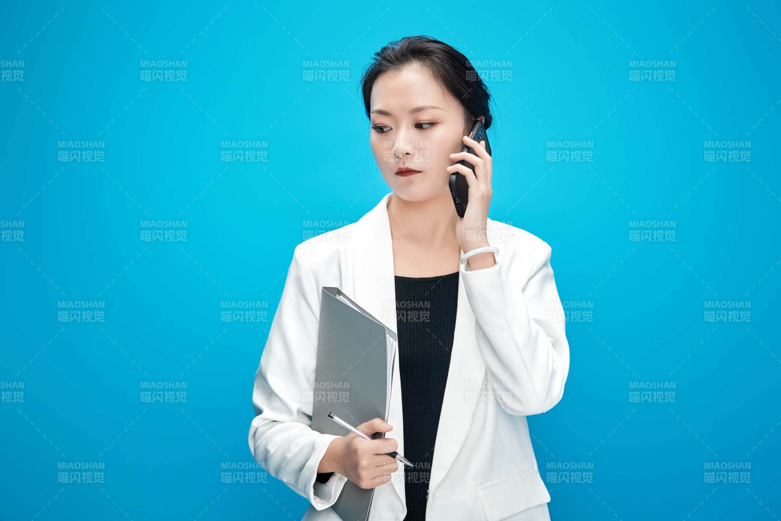 身穿西服拿着手机与文件夹的亚洲商务女士图片