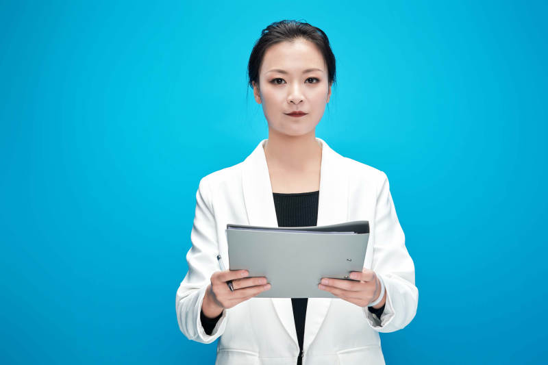 身穿西服拿着手机与文件夹的亚洲商务女士图片